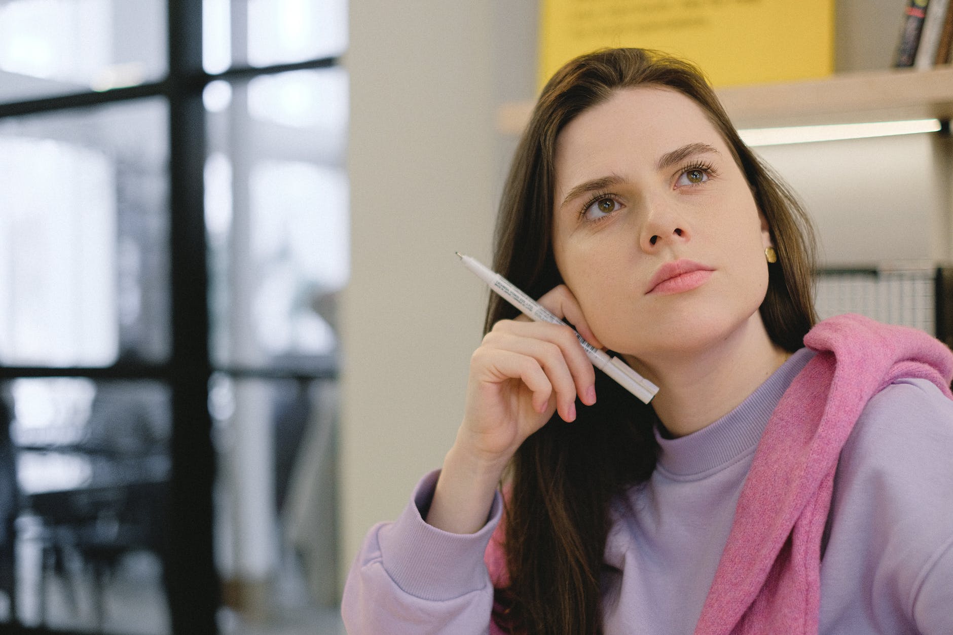 smart young female student looking away thoughtfully during lesson in college