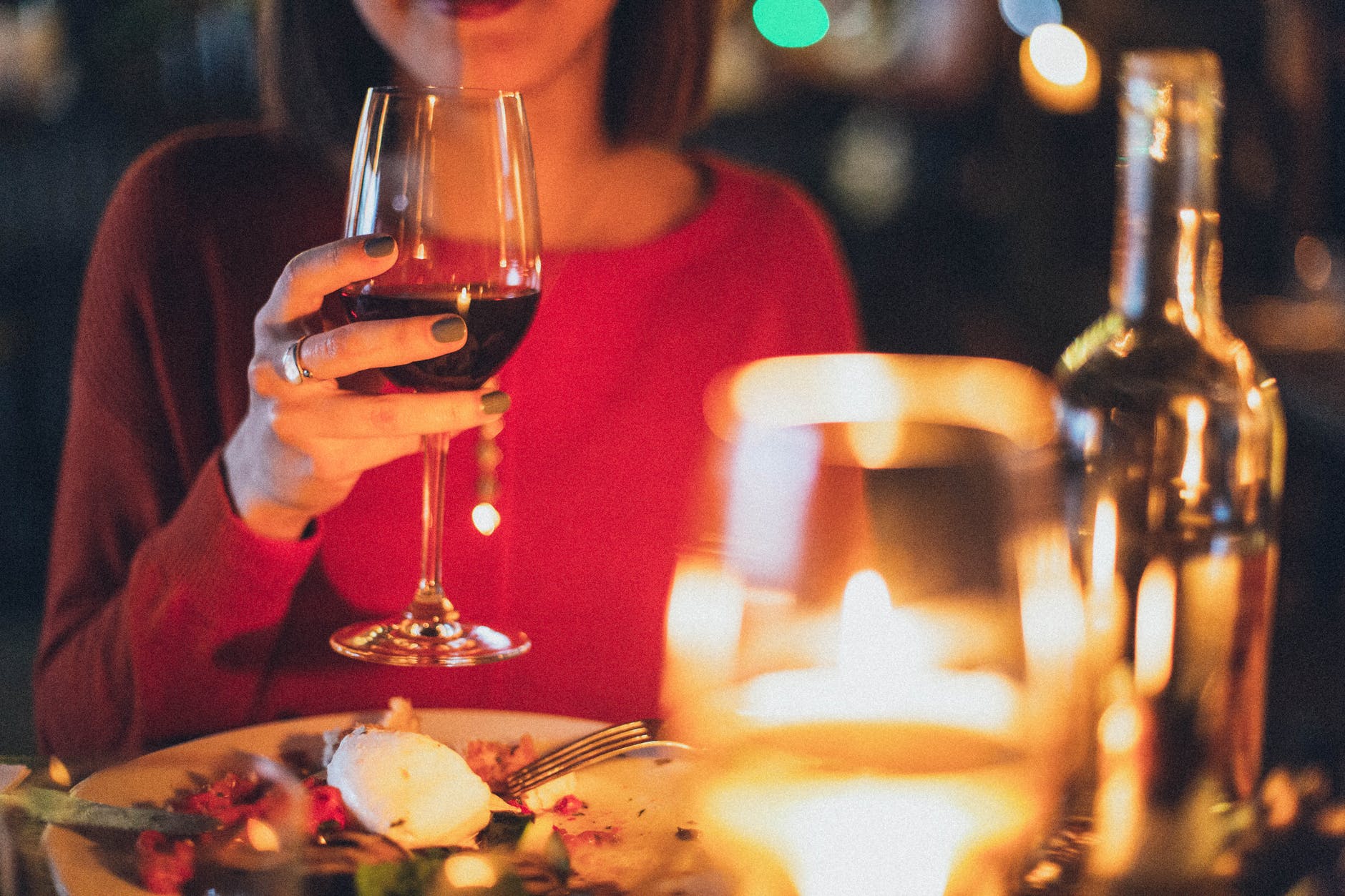 woman holding wine glass selective focus photography